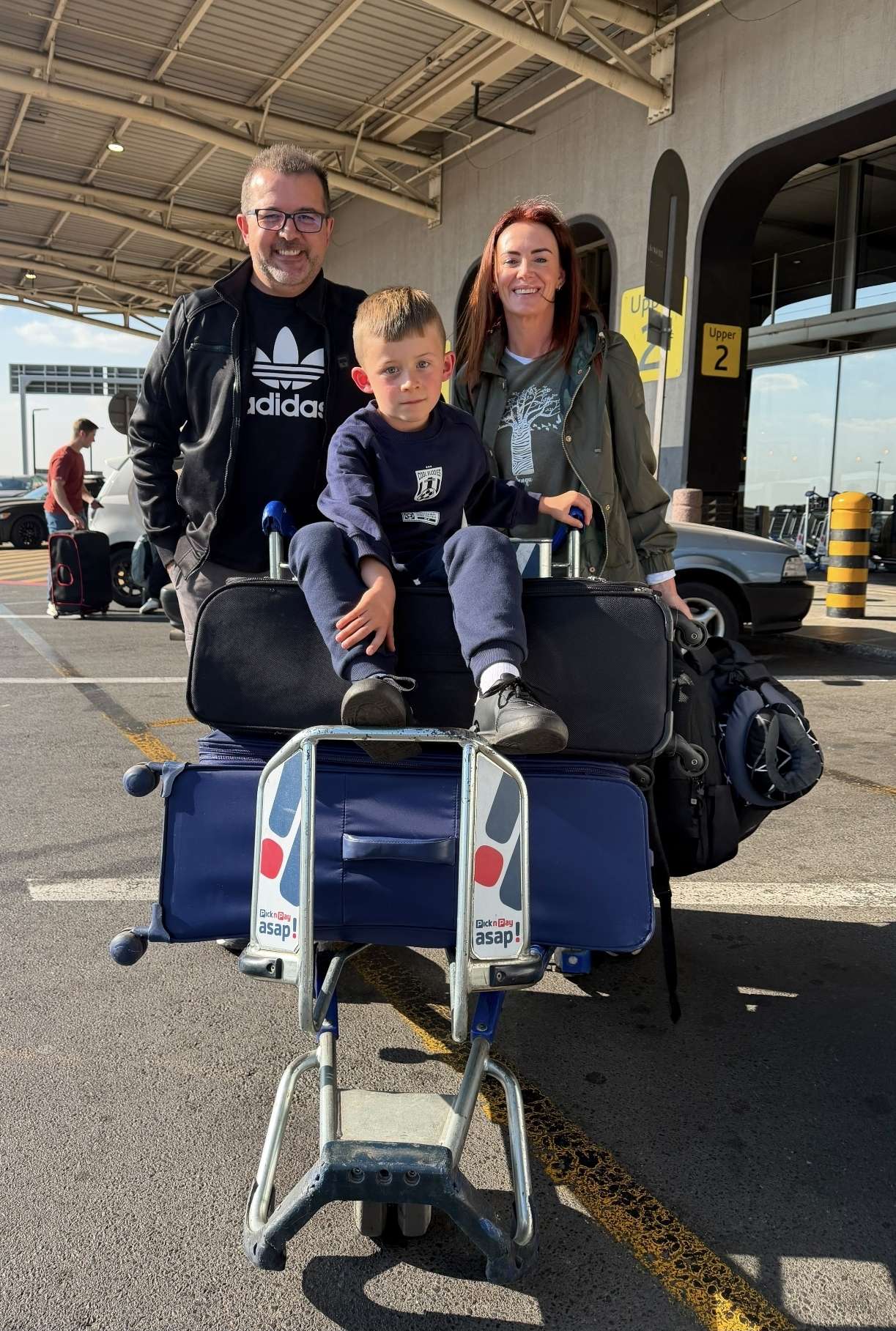 The family with their luggage at O. R. Tambo International Airport, ready to depart for America.